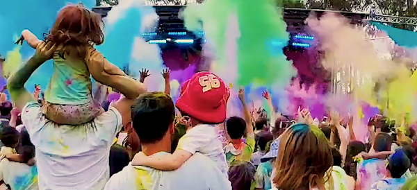 crowd of people with coloured powder in the air